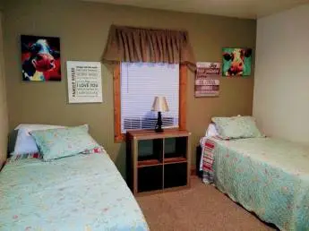 Cozy bedroom with two beds at KISA Life Recovery detox center in Kansas.