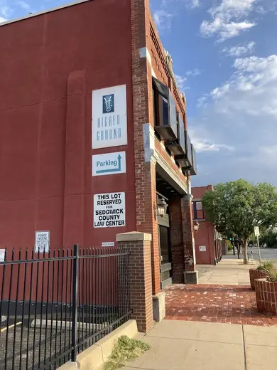 Brick exterior of Higher Ground detox center in Kansas with clear signage and parking area.
